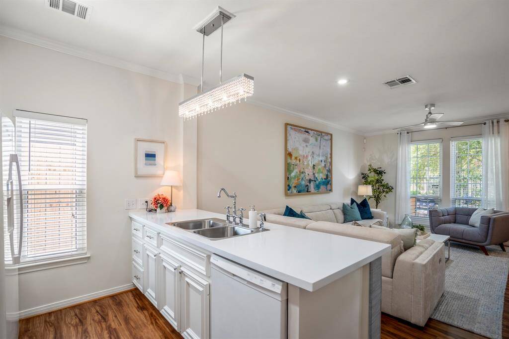 Hardwood floors add warmth, and a stylish light fixture enhances the modern feel.