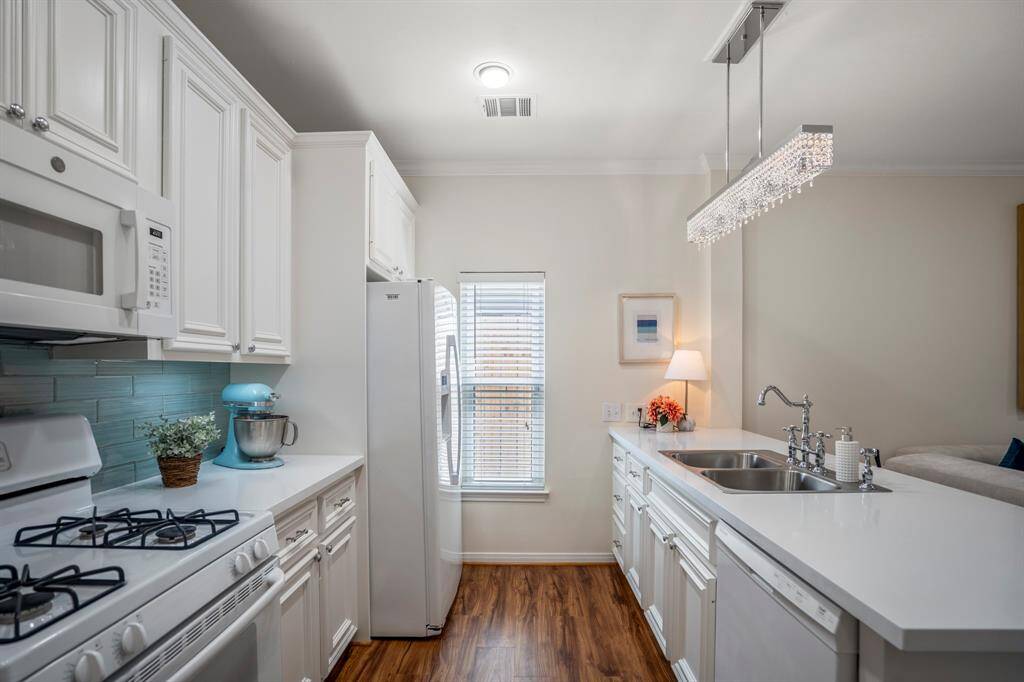 The kitchen features a large window for natural light, a sleek countertop with a sink, and a stylish overhead light fixture. Perfect for culinary enthusiasts and entertaining.