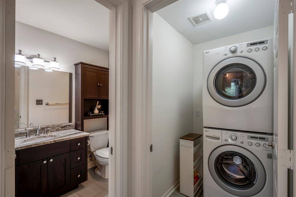 Adjacent to the full bathroom is a laundry area with stacked washer and dryer units, maximizing space efficiency.
