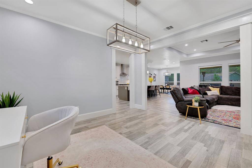 Stunning open-concept view encompassing the living room, kitchen, flex space, and grand entry—perfectly designed for both elegance and functionality.