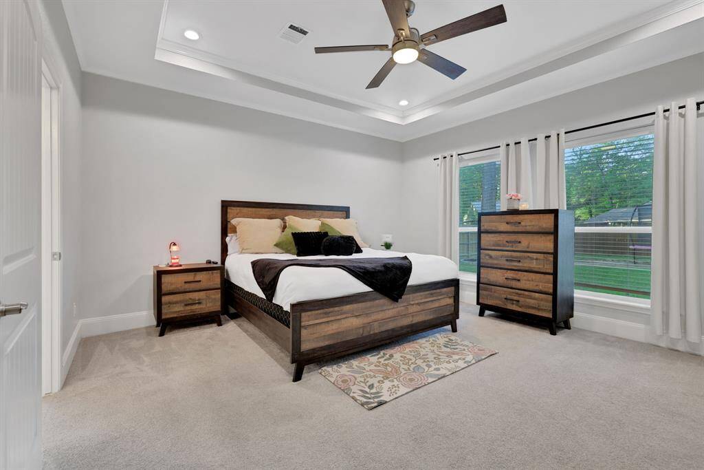 The spacious primary bedroom features an elegant en suite, stunning tray ceilings, and beautiful windows that frame peaceful views of the backyard.