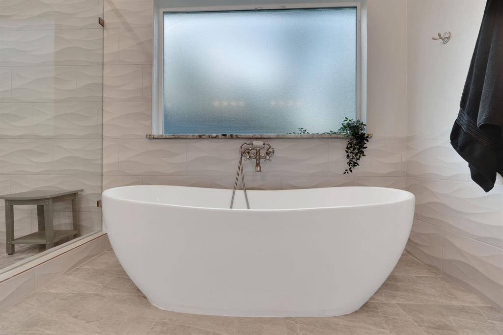 Designed for indulgence, this soaking tub offers a tranquil escape within the beautifully appointed primary suite.