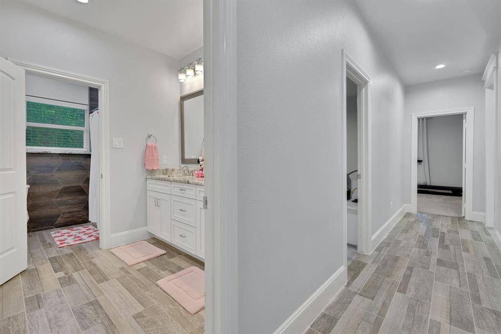 A thoughtfully designed hallway leads to three spacious secondary bedrooms and a luxurious dressing area, complete with a separate soaking tub and private water closet—offering comfort, privacy, and convenience for family or guests.