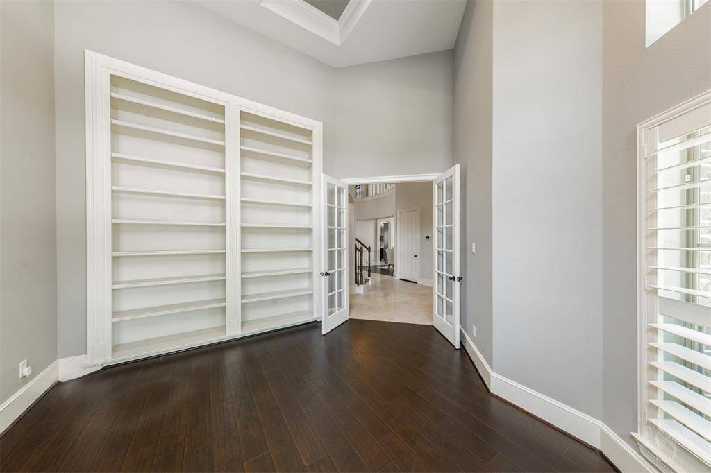 Your dedicated office with high coffered ceilings, French doors, and built-in bookshelves.