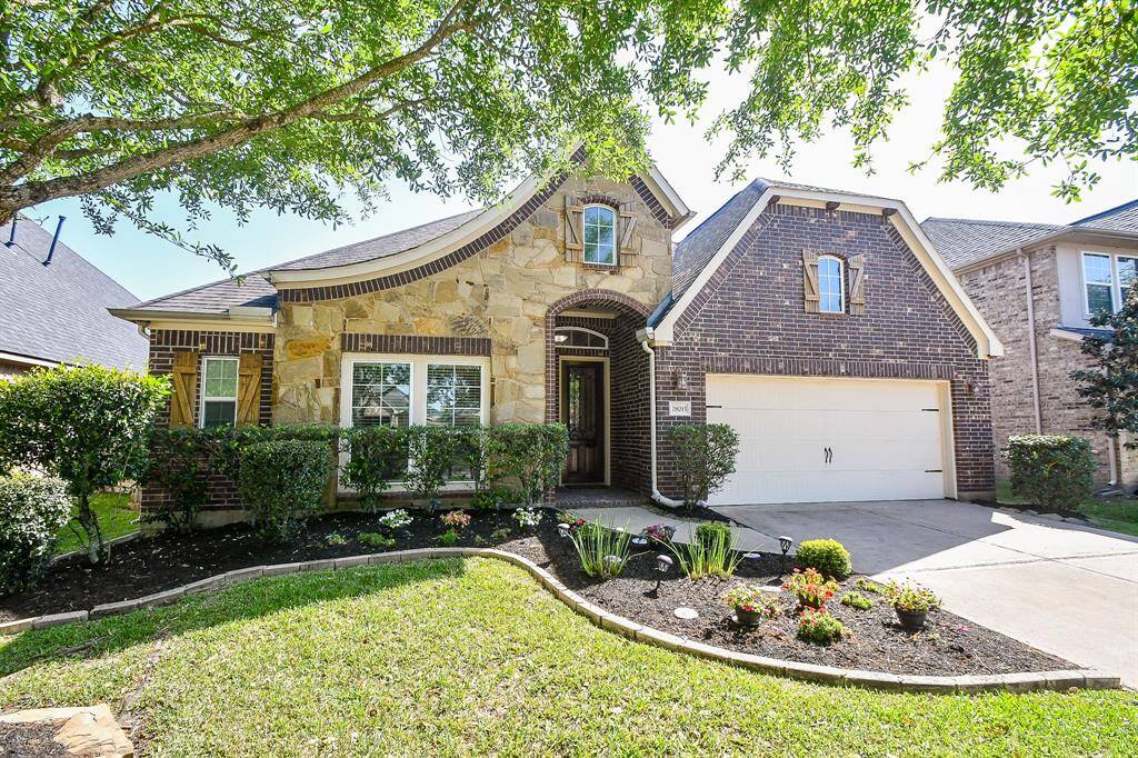 Charming one and half-story home with a blend of brick and stone exterior. Features a well-maintained front yard, mature trees, and a two-car garage. The welcoming entrance adds to its curb appeal.