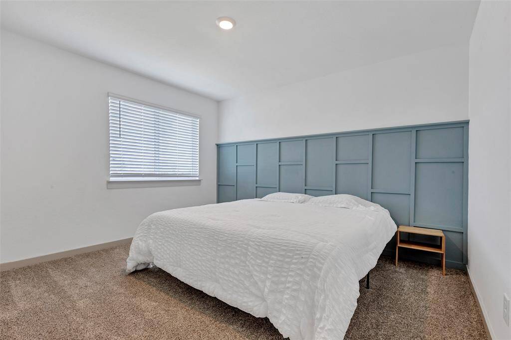 Welcome to the front bedroom, a versatile space that can be styled to reflect the owner's personal taste, featuring cozy carpeting and a glass window that invites plenty of natural light.