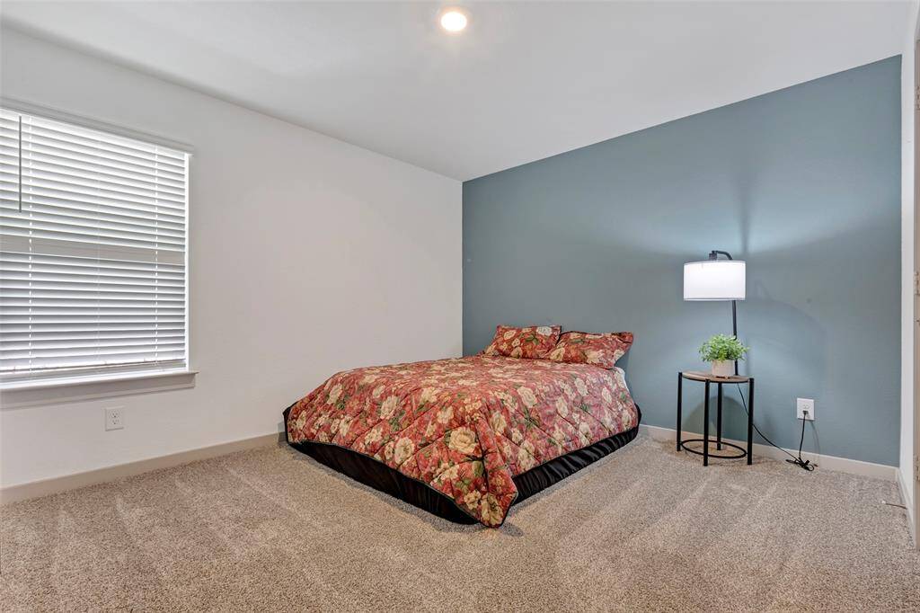 The second bedroom offers a cozy carpeted floor and a large glass window and a whole lot of ideas on how to style it.