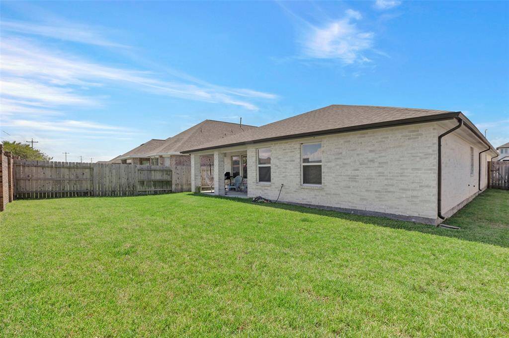 Enjoy a wider view of the spacious backyard, beautifully carpeted with lush green grass, making it the perfect setting for gatherings and outdoor fun.