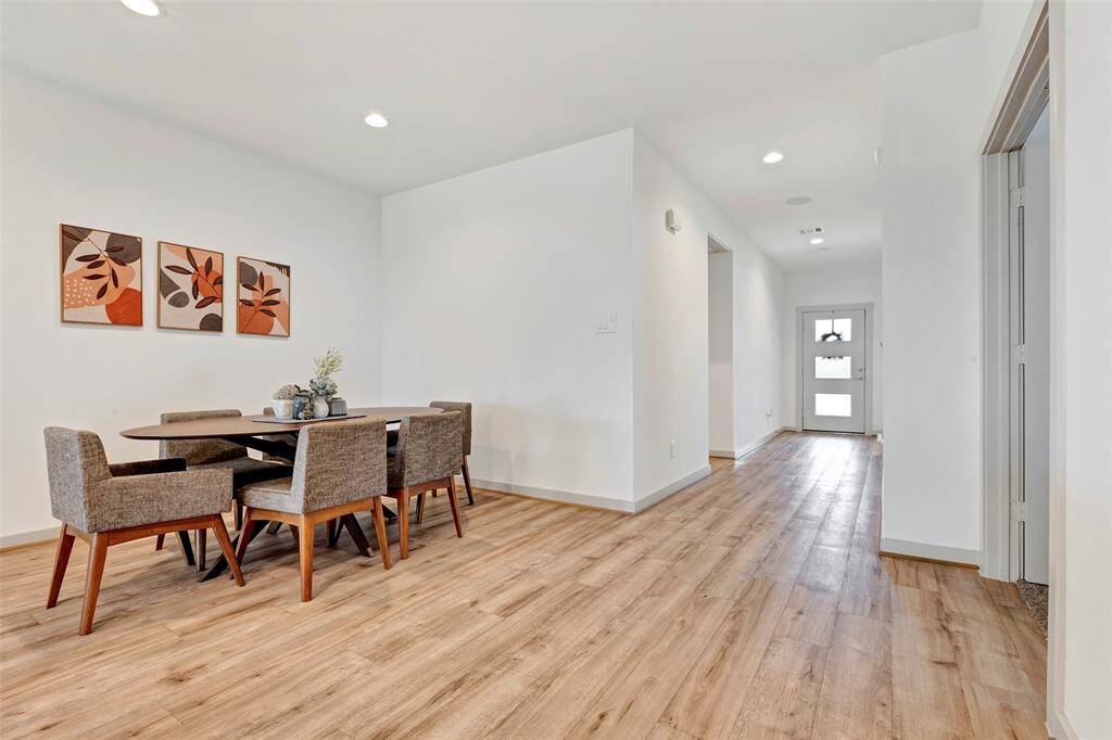 Nestled in a cozy corner, the dining area flows effortlessly into a hallway lined with doors leading to inviting bedrooms.