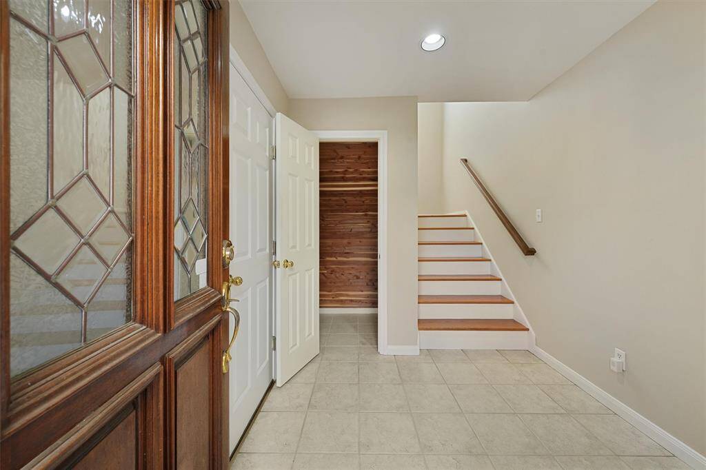 Two story open foyer with cedar closet for seasonal storage.