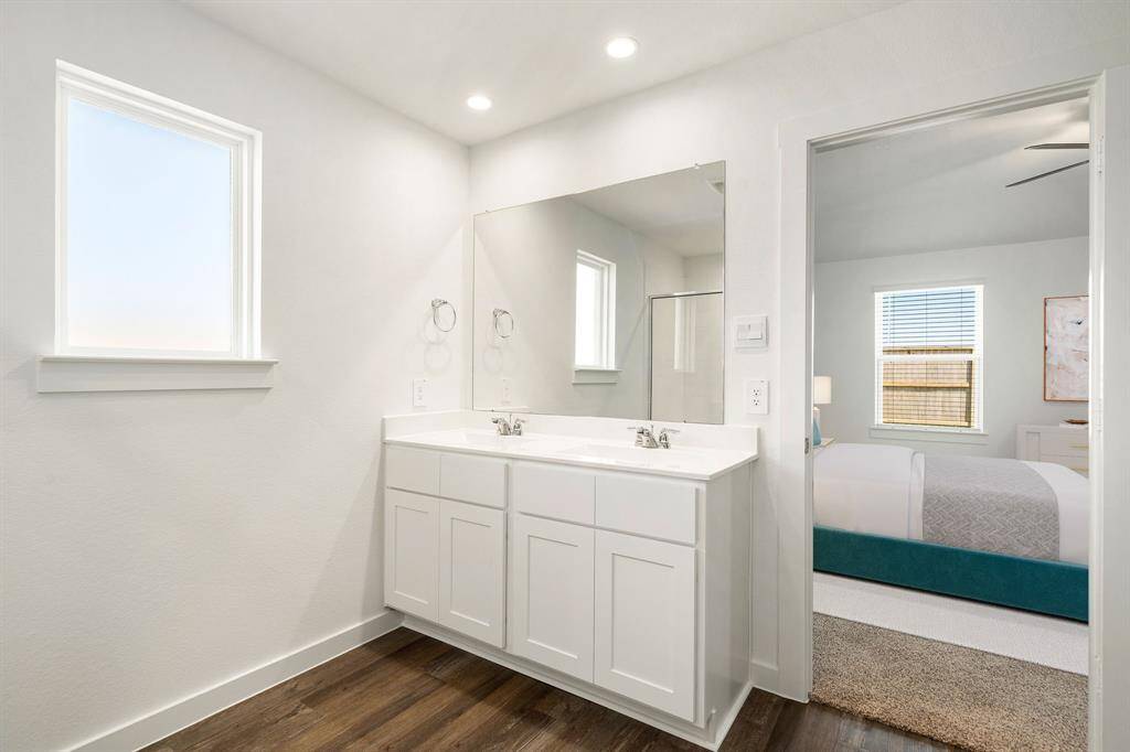 This primary bathroom is definitely move-in ready! Featuring a spa like walk-in shower with tile surround, separate garden tub for soaking after a long day with custom tile detailing, bright cabinets with light countertops, spacious walk-in closet with shelving, high ceilings, custom paint, sleek and modern finishes.