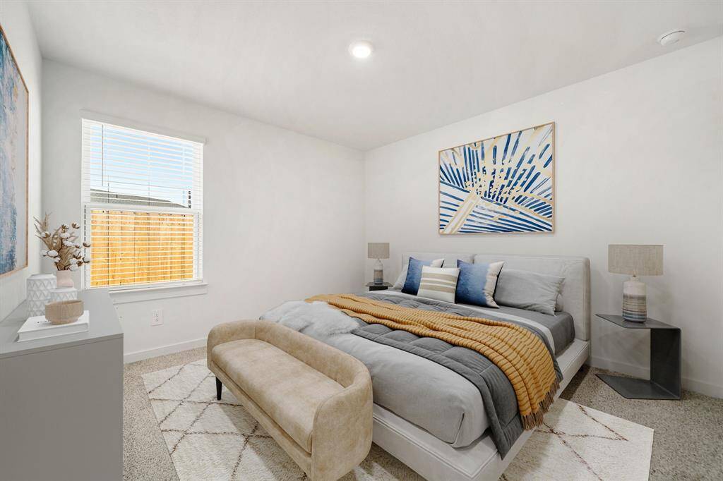 Secondary bedroom features plush carpet, lighting and a large window.