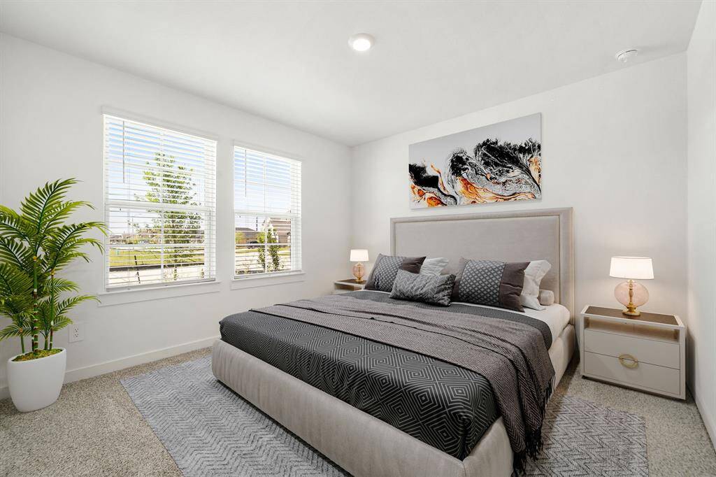 Secondary bedroom features plush carpet, lighting and a large window.