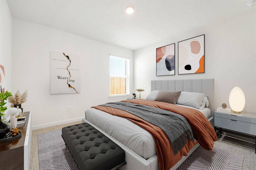 Secondary bedroom features plush carpet, lighting and a large window.