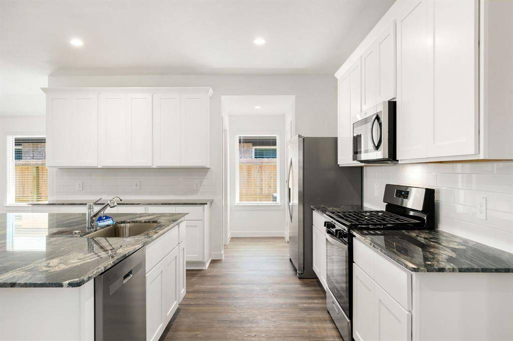 This kitchen is by far any chef’s dream! This spacious kitchen features high ceilings, bright white cabinets, granite countertops, SS appliances, recessed lighting, granite kitchen island with double sink and space for breakfast bar, and a walk-in pantry all overlooking your huge family room.