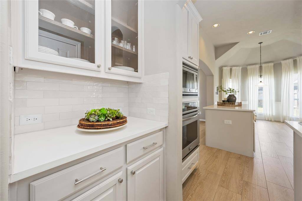 Chic butler’s pantry featuring glass-front cabinets — the perfect blend of style and storage, ideal for displaying your favorite pieces.