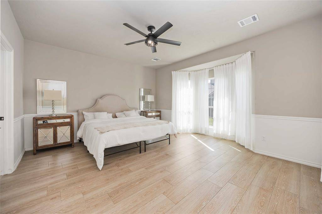 Bright and airy Primary Suite featuring charming bay windows that invite in natural light and offer a cozy nook with a view.
