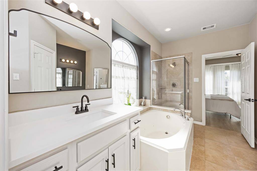 The primary bath includes a second vanity with its own sink, offering a true double sink setup with separation for added convenience and personal space.