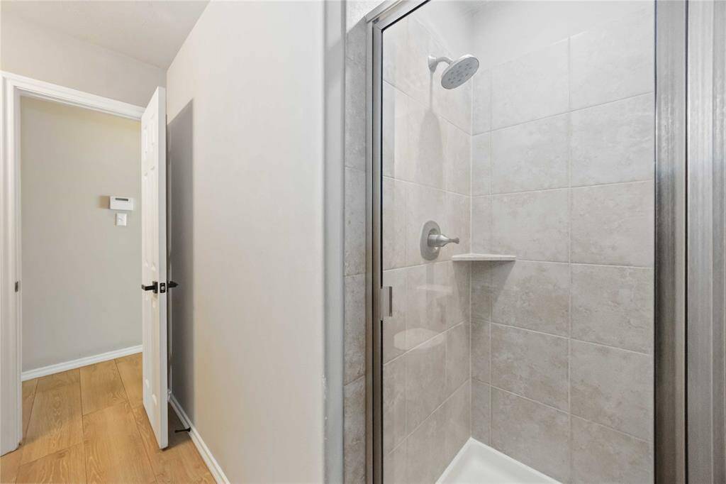 From this angle, the first-floor bathroom showcases its modern stand-up shower, contemporary fixtures, and thoughtfully designed layout—perfectly complementing the nearby secondary room.
