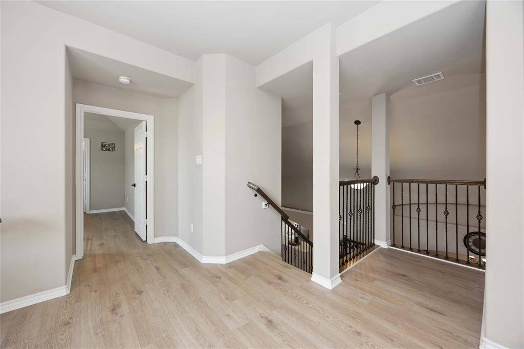 Upstairs features beautiful flooring with no carpet, while the open stairwell offers a striking overlook of the living area below — blending style with architectural interest.