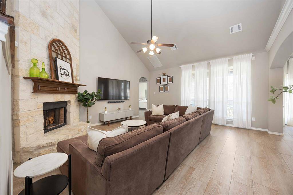 Open concept living room exudes timeless elegance and cozy comfort, featuring soaring ceilings and a stunning stone fireplace as the focal point.Want to add in anything like wood beams, natural light, or furniture style? I can help fine-tune it!