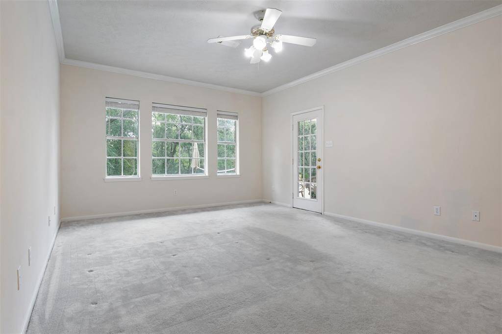 The spacious master bedroom offers abundant natural light, thanks to multiple windows that also provide stunning views of Chigger Creek. A door leading directly to the backyard allows for easy outdoor access.