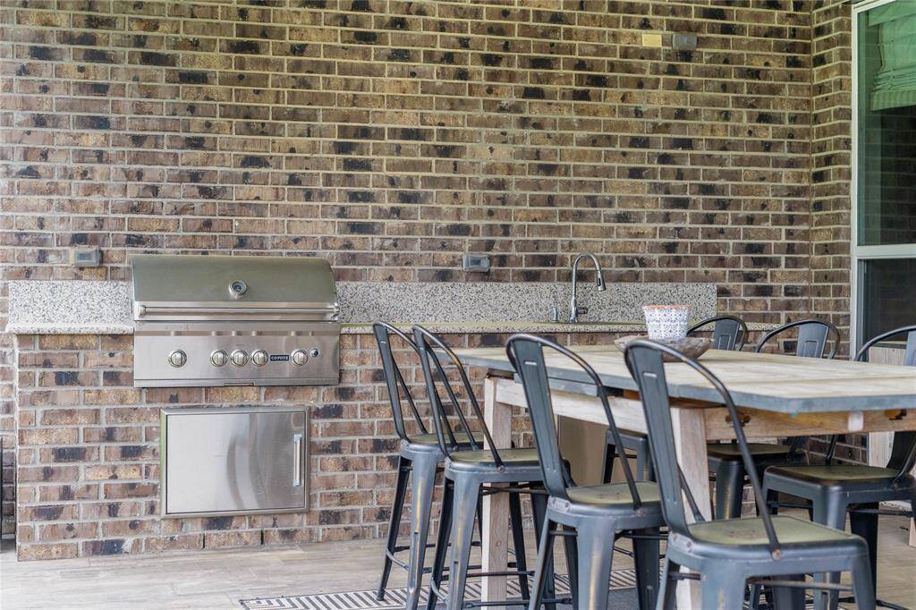 Outdoor kitchen with grill, prep space and sink for easy cleanup.