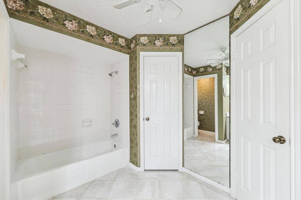 Primary bathroom with tub/shower combo, ceiling fan, dual closets and full length mirror
