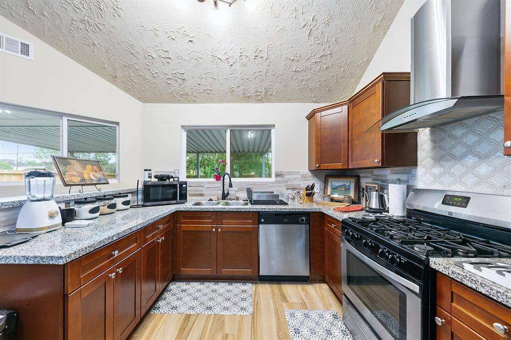 Clever window placement means there is always a view of the big back yard from the kitchen! The kitchen was remodeled with granite counters and stainless appliances, and plenty of cabinets!