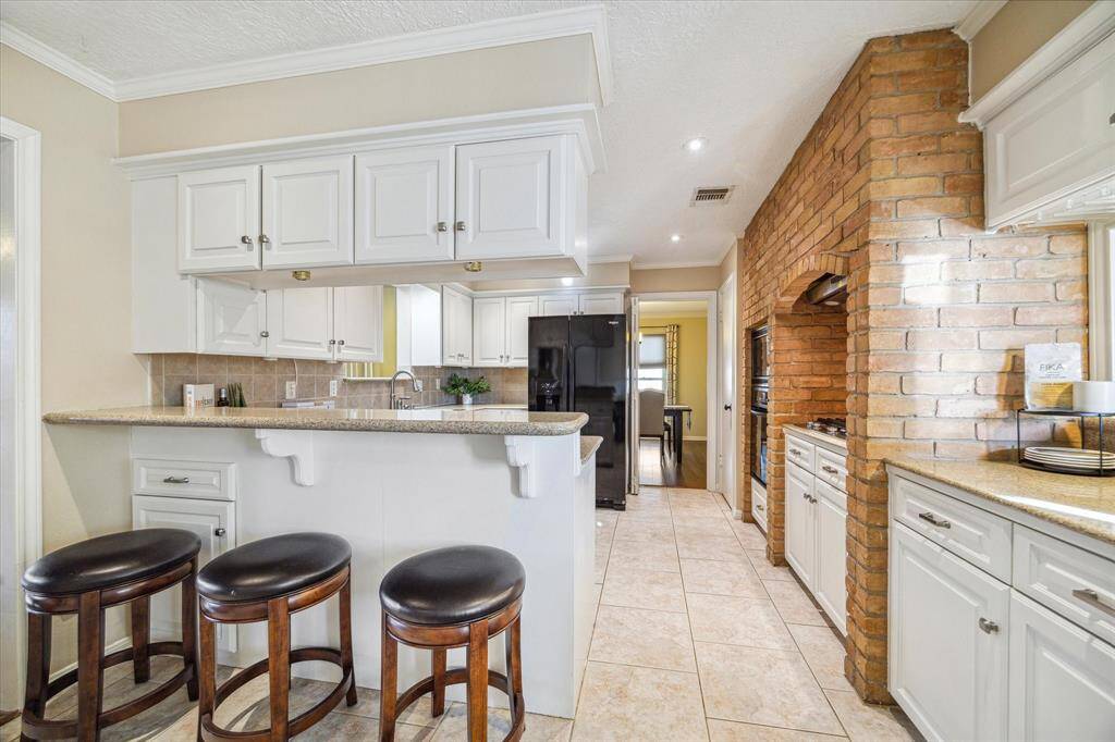 The kitchen is separated from the breakfast area by a raised bar with storage above and below. This bar is a handy feature for serving drinks and snacks or add bar stools to create additional seating.