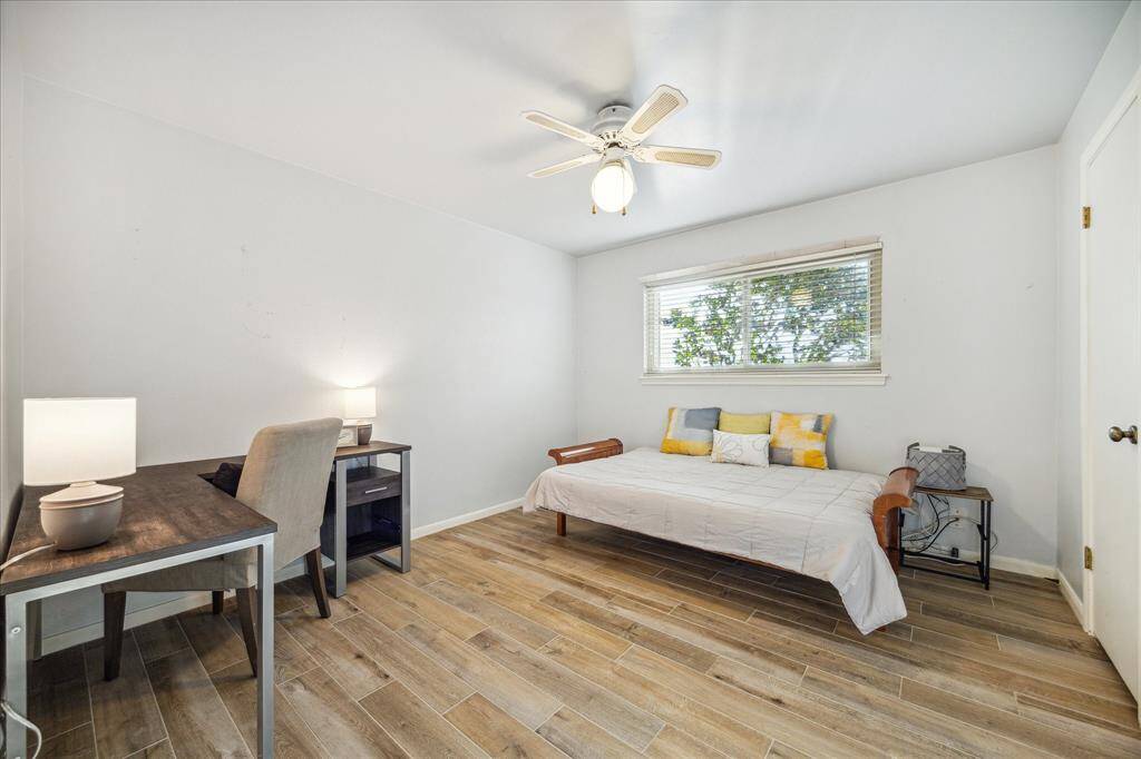 Guests will feel right at home in this spacious bedroom. This spacious bedroom offers wood-look tile flooring, neutral paint, a lit ceiling fan, a large closet and easy access to a full bathroom.