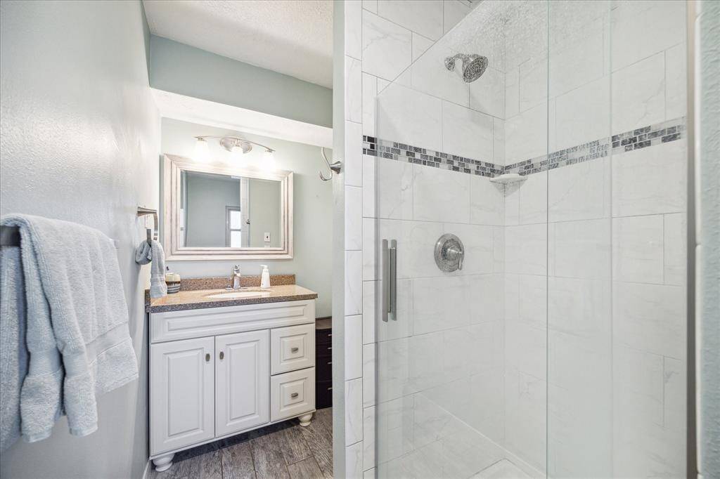 The guest quarters offer a full updated bathroom with an updated vanity and a beautiful walk-in shower with frameless glass and sleek tile work.