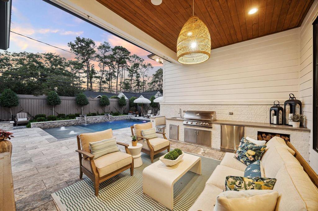 Beautiful outdoor patio with full outdoor kitchen and firewood storage for fire pit.
