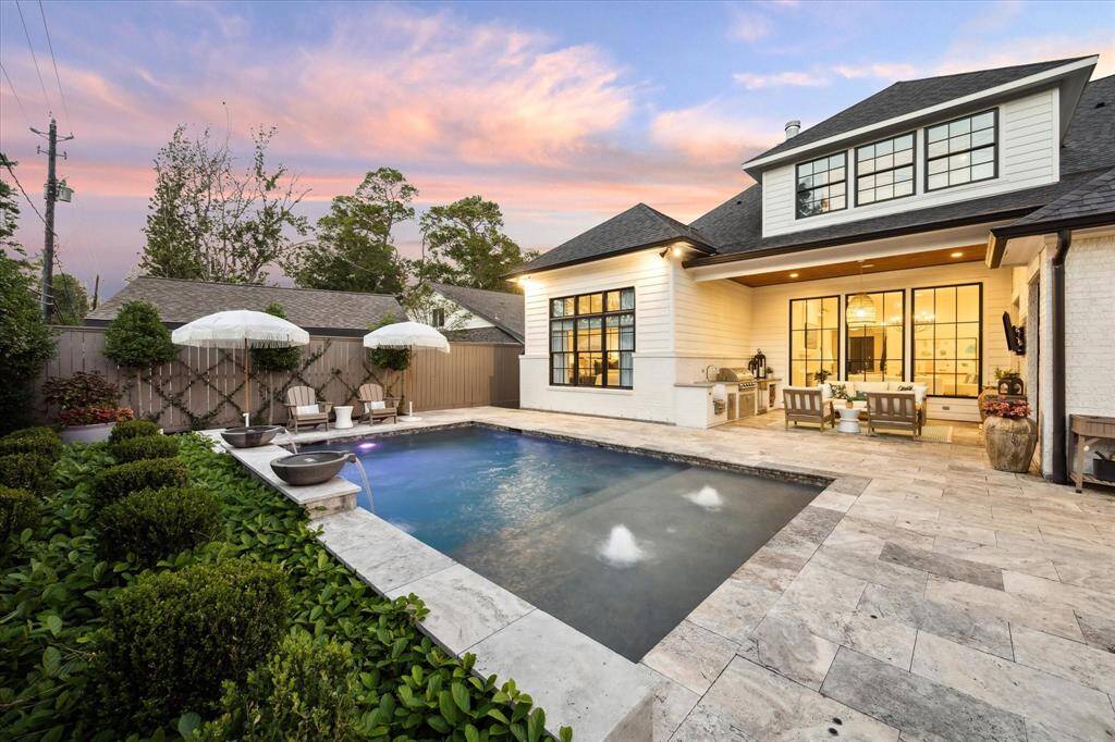 Heated pool with pebbletec finish, water feature wall and travertine surround.