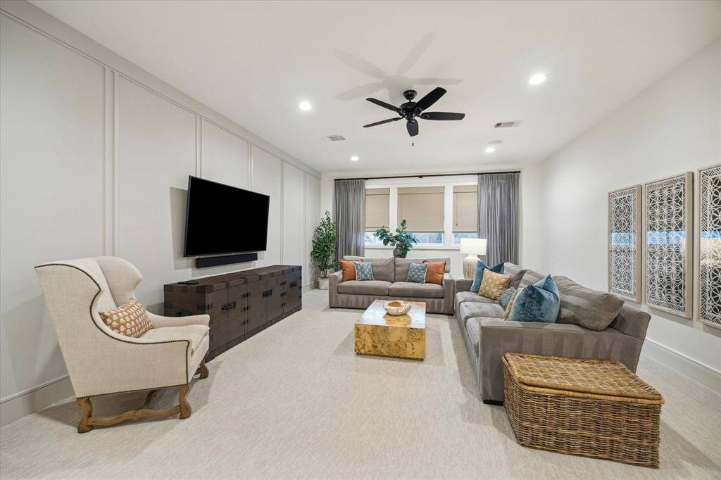 Expansive game room with wood paneled walls. Shades and drapery convey, which can be closed to make the room virtually black-out, for a media room if needed.