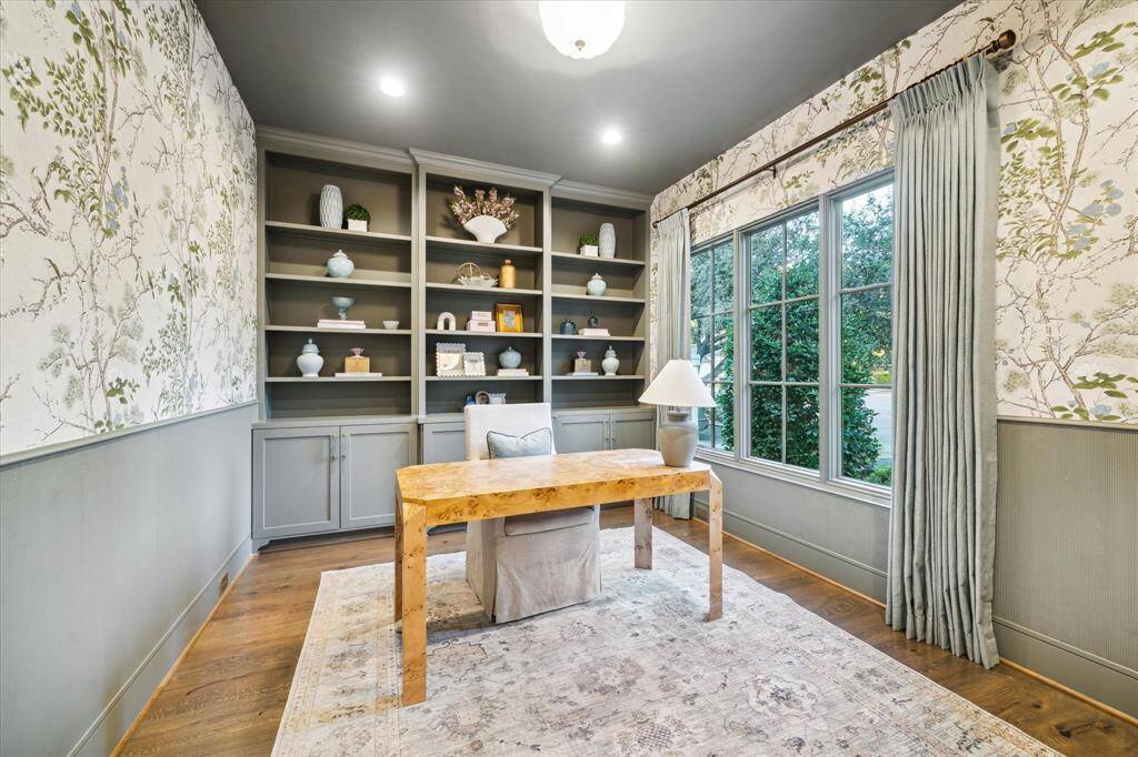 Home office at front of home with designer wallpaper, fluted paneling and custom built-ins.