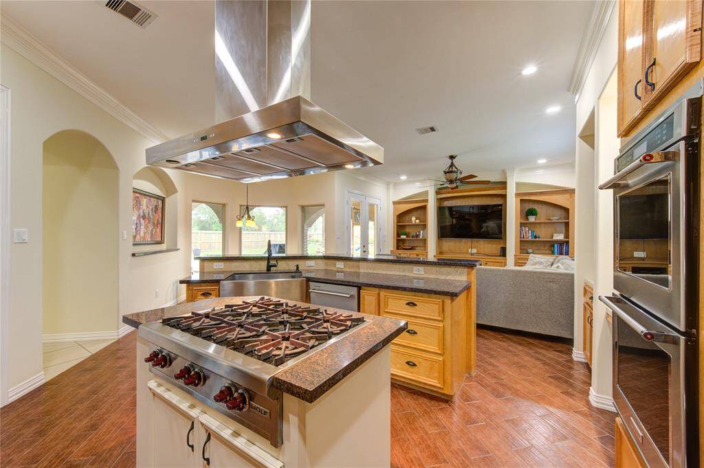 Kitchen is perfectly equipped with a commercial WOLF 6-burner gas range, double ovens and lighted commercial grade vent hood.
