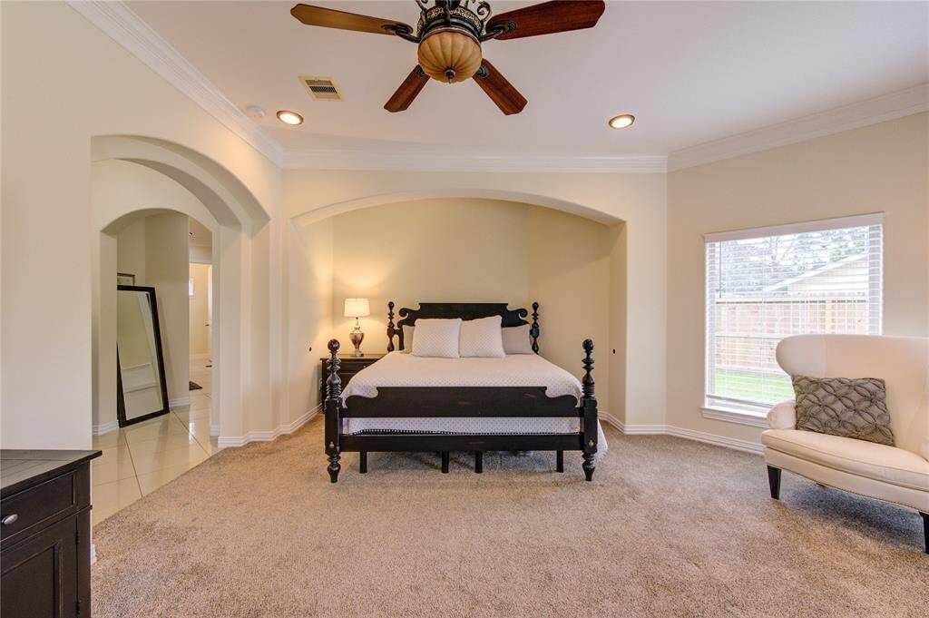 Secluded primary bedroom suite with generous space, en-suite bath, recessed and natural lighting and a full view of veranda/pool area.