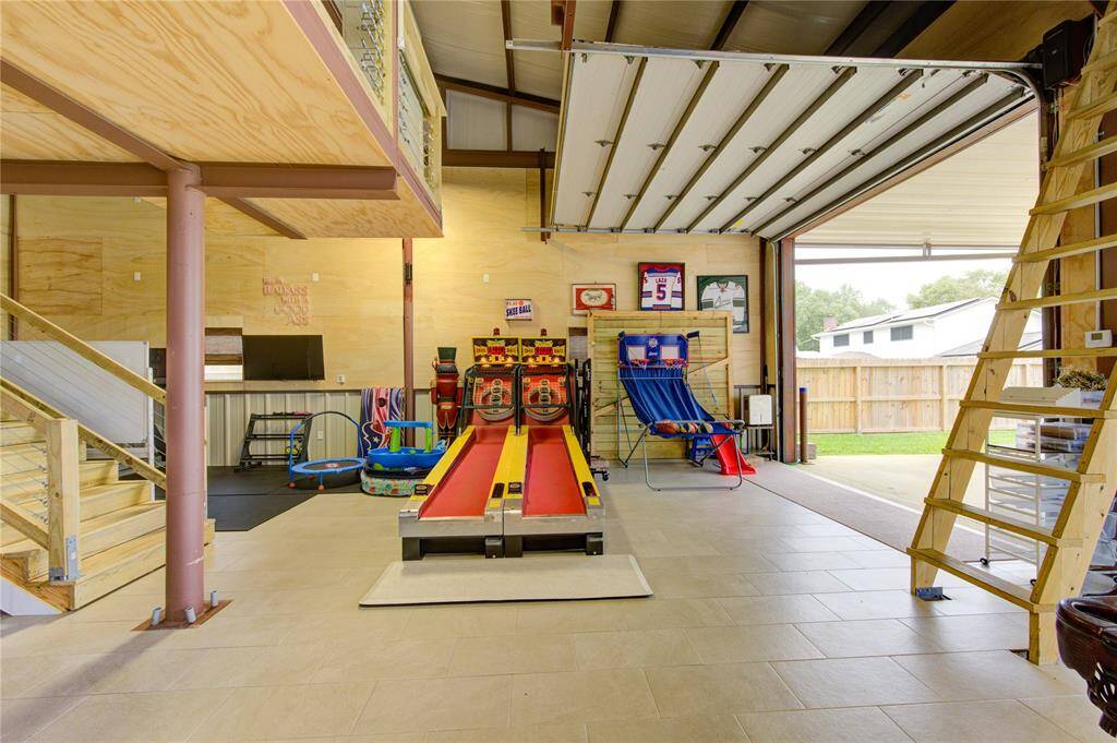 Seller installed ceramic tile flooring to the entire garage area. Stairs to left lead to loft, stairs to right lead to additional storage! Furnishings, decor, tv's, refrigerators excluded from sale. The space is air conditioned but with the 3 large roll top doors, you may not even need the A/C. Room to park RV's, ATV's and assortment of toys!