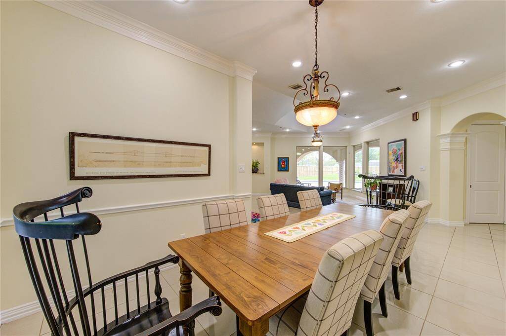 Alternate view of the formal dining area looking beyond the living room and out to the pool and outdoor living space.