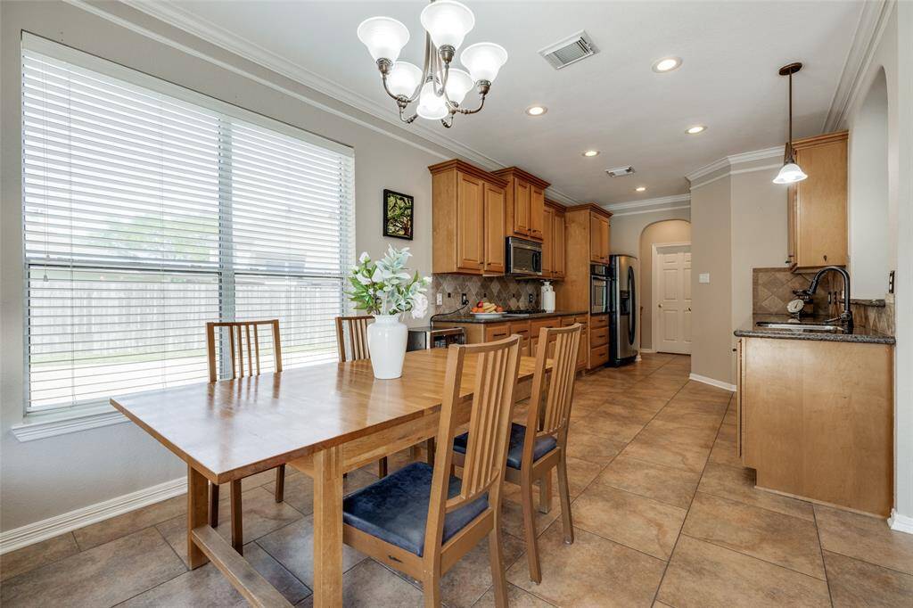 Breakfast Room, tiled floors, chandelier, wooden kitchen cupboards, gas cook top, SS refrigerator, recessed lighting, tiled back splash