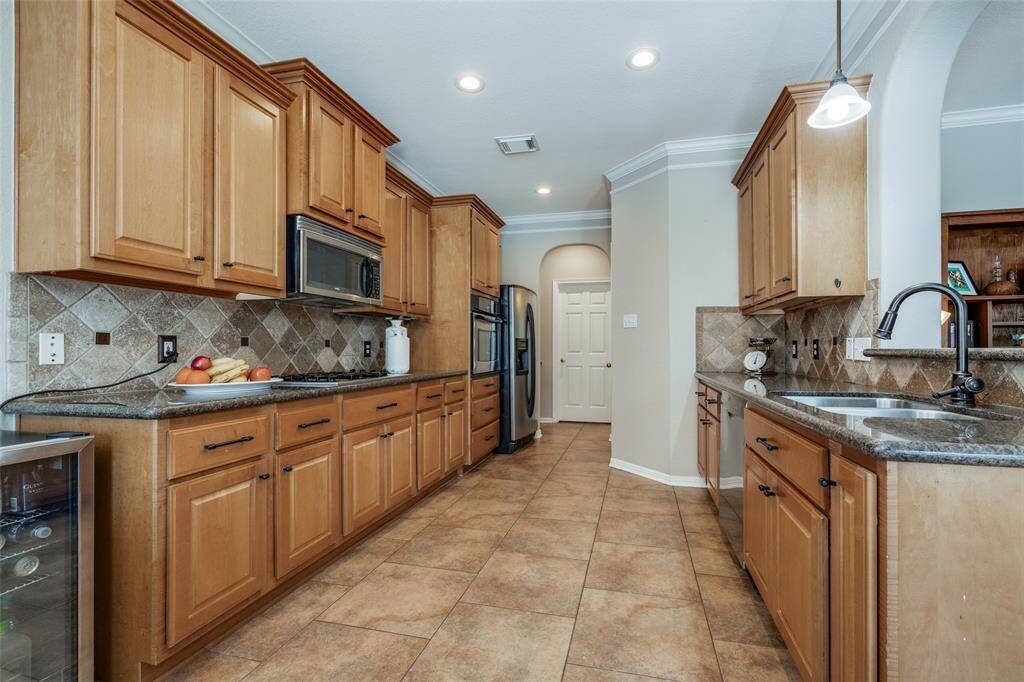 Kitchen with lots of cabinets, granite counter, SS appliances, tile floor