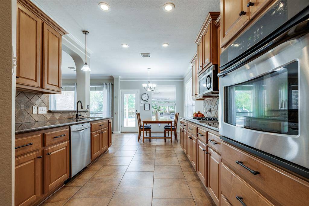 Kitchen with lots of cabinets, granite counter, SS appliances, tile floor