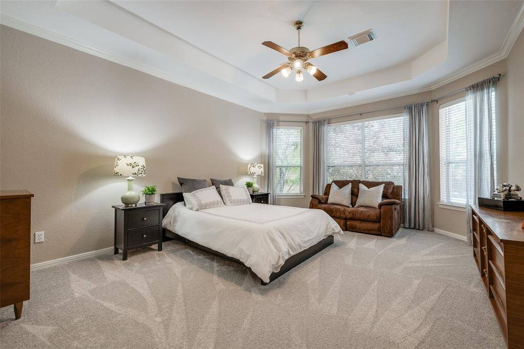 Primary bedroom downstairs, carpet 2024, high ceiling, ceiling fan, sitting area