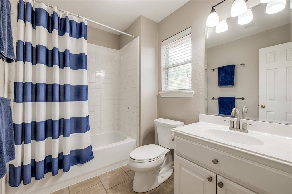 Bathroom 2 with over the bath shower, white wall tile, tiled floor, 2 in blind