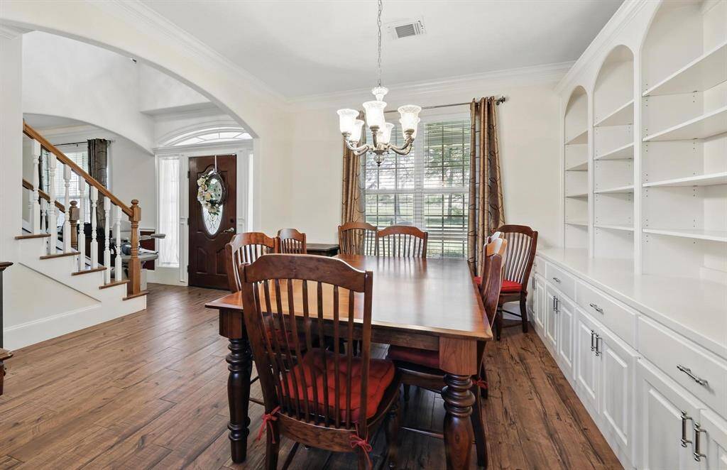 This view offers another perspective of the formal dining room and the front entrance, featuring a beautiful, statement-making front door that adds charm and character to the home.
