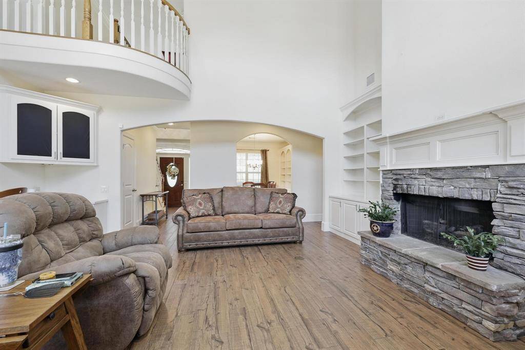 The family room features a stunning fireplace and is open to the second floor, creating a bright and airy atmosphere. Soaring ceilings extend throughout the home, adding to the sense of space and elegance.