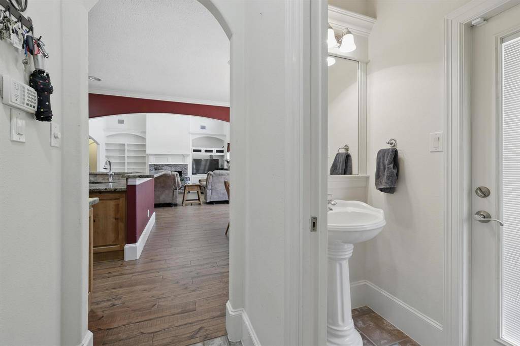 A conveniently located half bath sits just off the breakfast area and utility room, offering easy access for guests and everyday use.