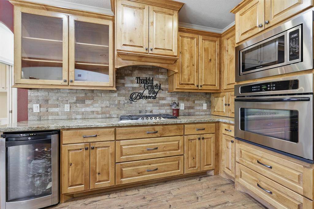 This spacious kitchen boasts beautiful upgraded cabinets offering ample storage, complemented by sleek granite countertops. A gas range and oven add both style and functionality, making it a dream for any home chef