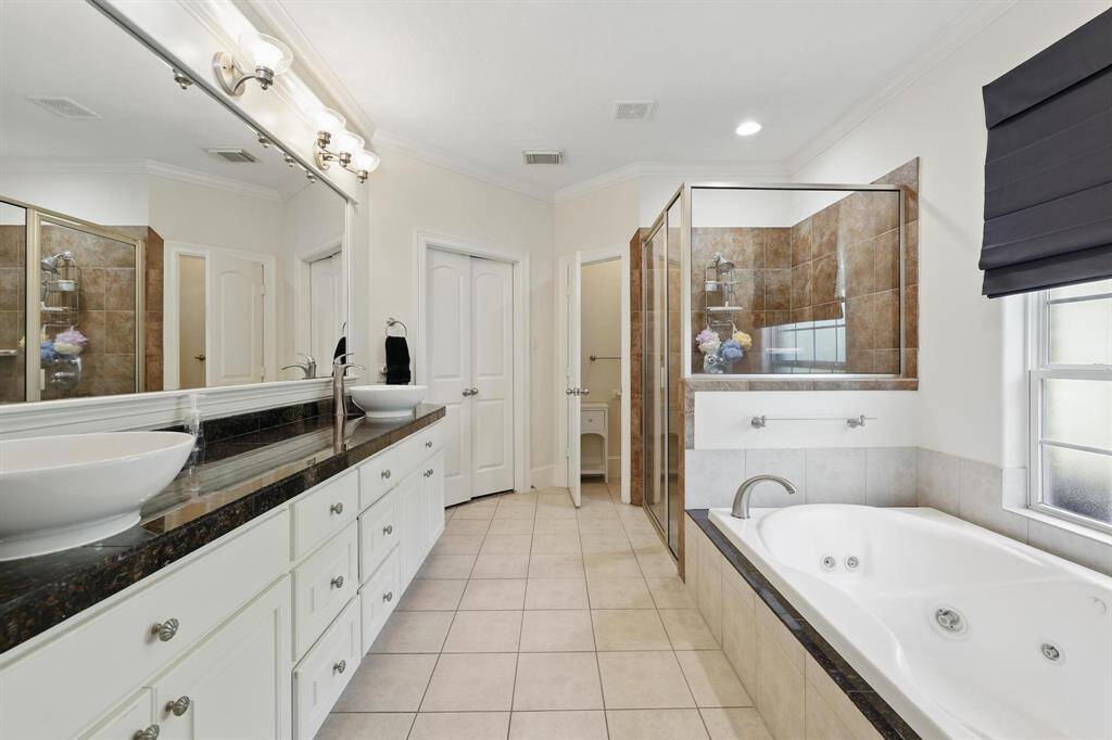 Imagine unwinding in this luxurious primary bath, featuring double sinks, a soothing jetted tub, and an oversized shower—perfect for relaxing after a long day.